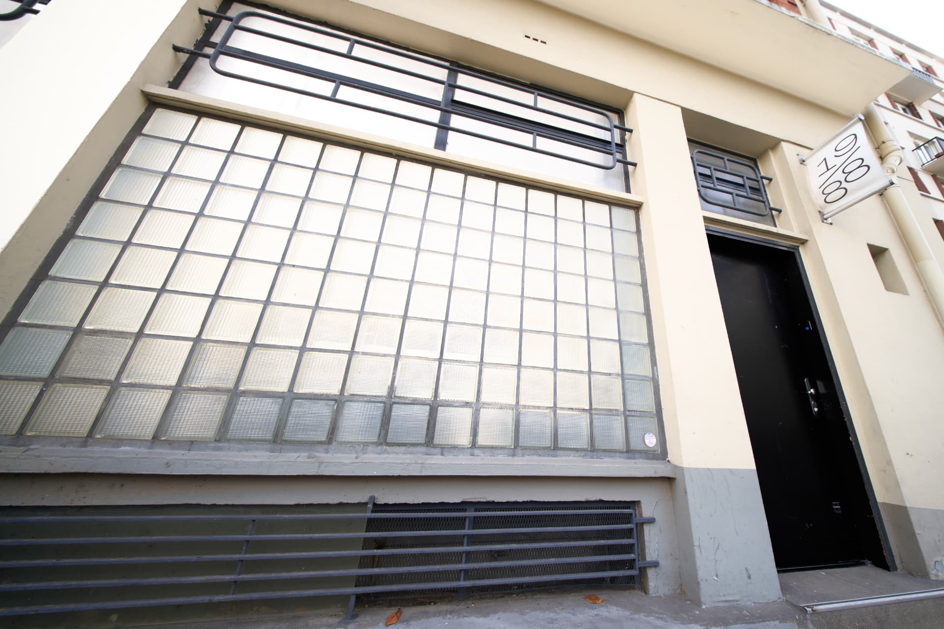 Entrée du studio — façade vitrée et porte noire 19/88