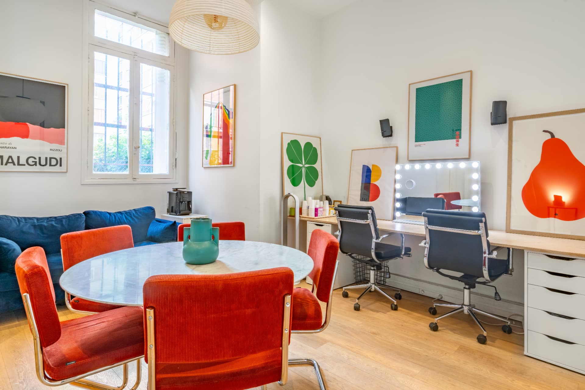 Table ronde en marbre, fauteuils orange et miroirs make-up