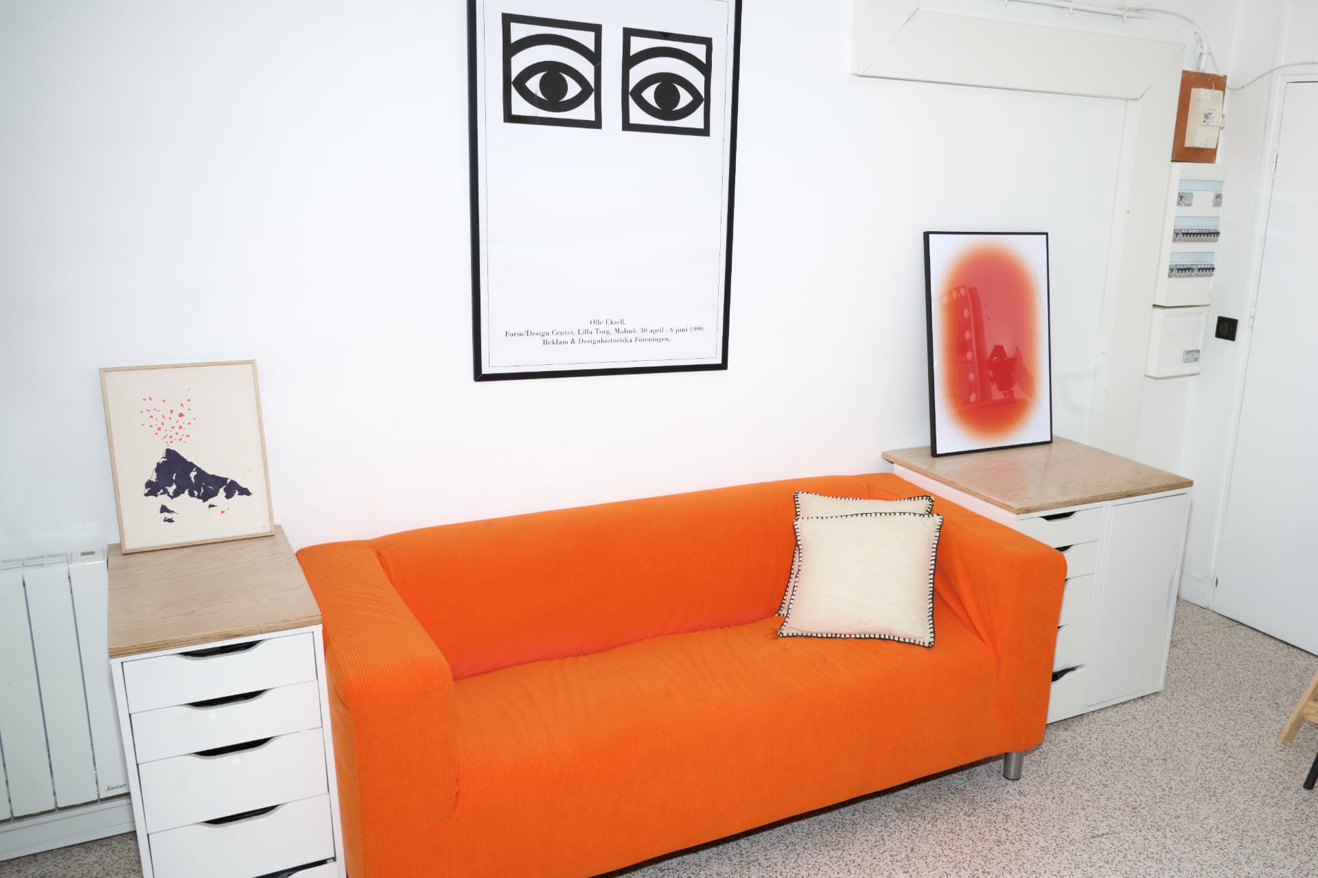 Canapé orange avec affiches encadrées