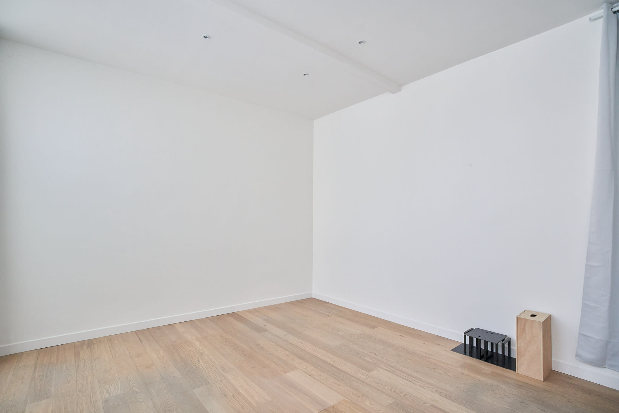 Angle épuré du plateau avec parquet et murs blancs